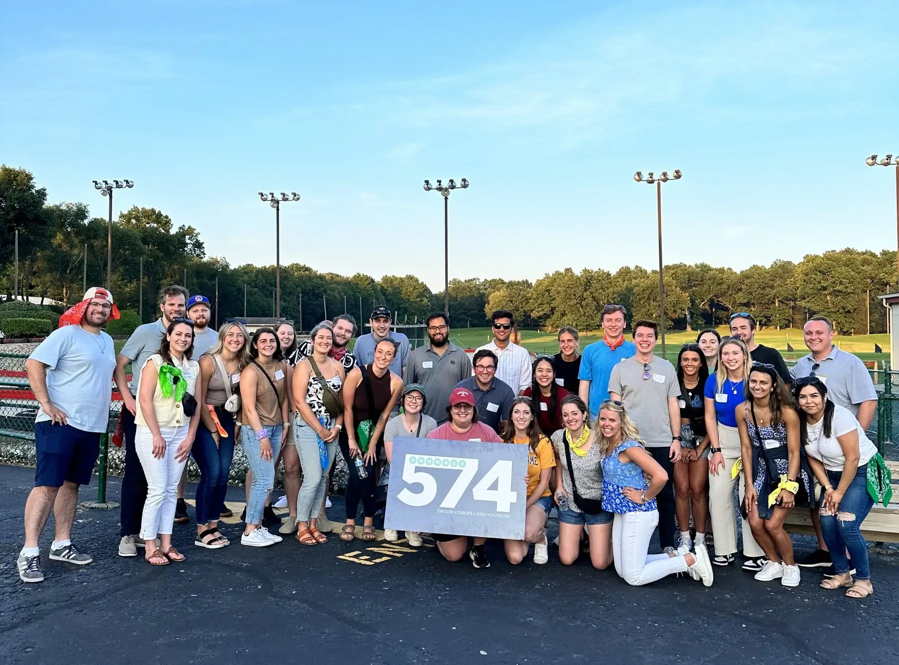 A big group of Connect 574 members holding a 574 sign at an outdoor event